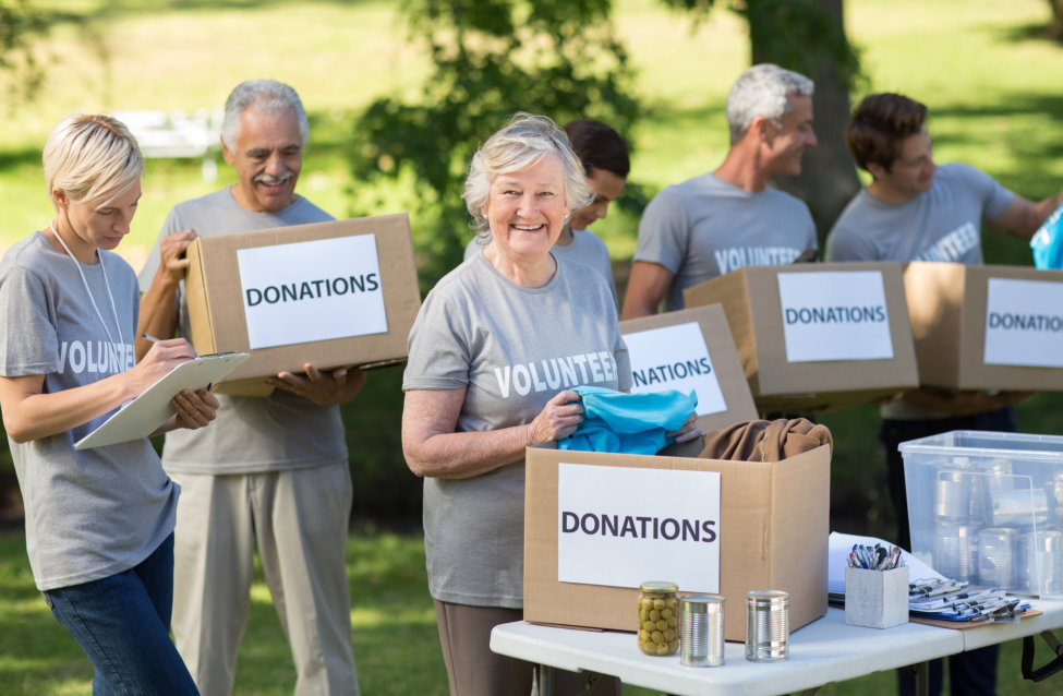 happy volunteers holding donations boxes